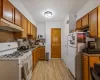 Kitchen featuring decorative backsplash, light hardwood / wood-style flooring, white appliances, and sink