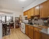 Kitchen featuring sink, light wood-type flooring, a textured ceiling, tasteful backsplash, and white range with gas cooktop