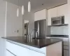 Kitchen featuring decorative backsplash, appliances with stainless steel finishes, sink, decorative light fixtures, and white cabinets