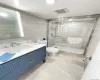 Bathroom with walk in shower, backsplash, toilet, vanity, and tile walls