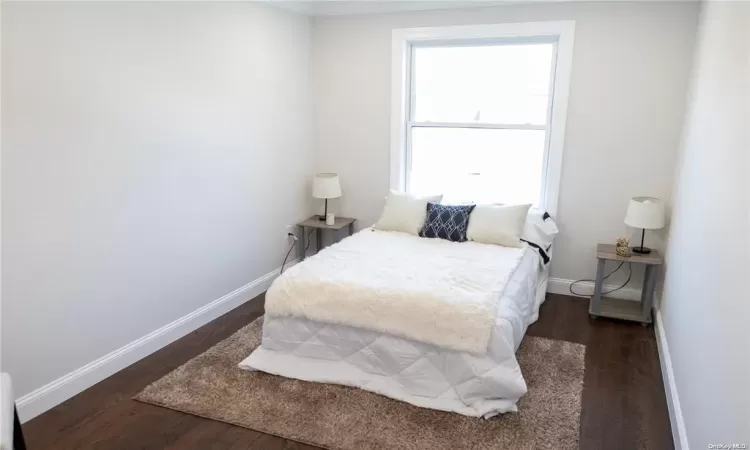 Bedroom with dark hardwood / wood-style flooring