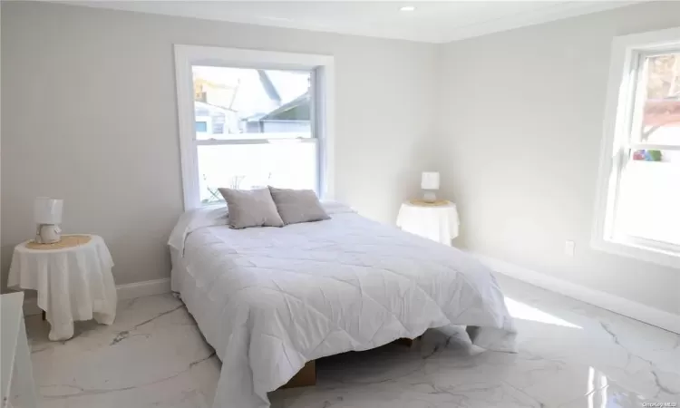 Bedroom featuring crown molding and multiple windows