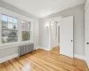 Unfurnished bedroom with radiator heating unit and light hardwood / wood-style floors