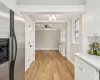 Kitchen featuring radiator, white cabinetry, ceiling fan, light hardwood / wood-style flooring, and stainless steel refrigerator with ice dispenser