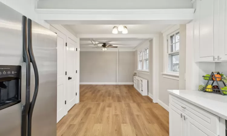 Kitchen featuring radiator, white cabinetry, ceiling fan, light hardwood / wood-style flooring, and stainless steel refrigerator with ice dispenser