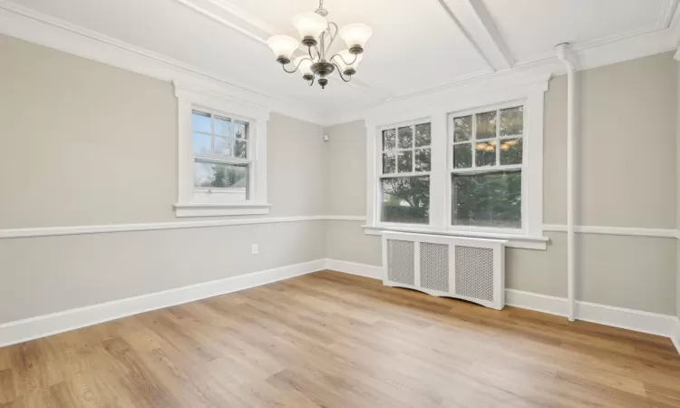 Dining room featuring crown molding, hardwood / wood-style flooring, a notable chandelier, beamed ceiling, and radiator heating unit