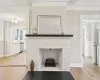 Room details with crown molding, dishwasher, wood-type flooring, and a brick fireplace