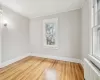 Bedroom with hardwood / wood-style flooring, crown molding, and radiator