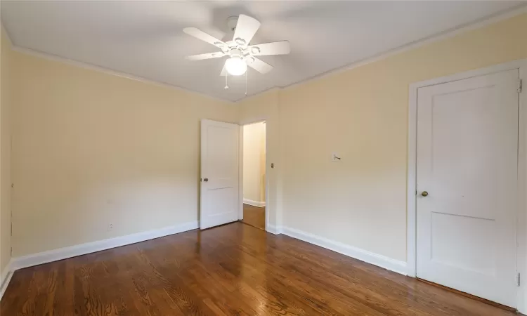 Spare room featuring crown molding, dark hardwood / wood-style flooring, and ceiling fan