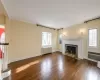 Living room featuring a fireplace, beautiful moldings and gleaming hardwood floors