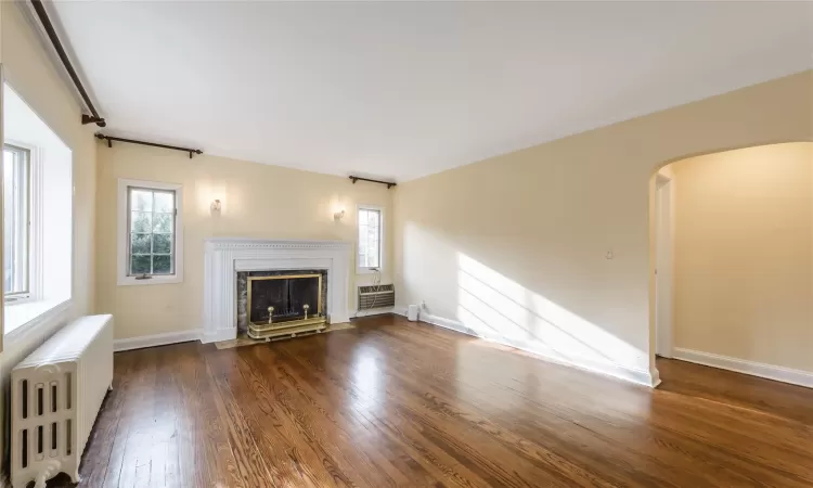 Living room featuring a fireplace, beautiful moldings and gleaming hardwood floors