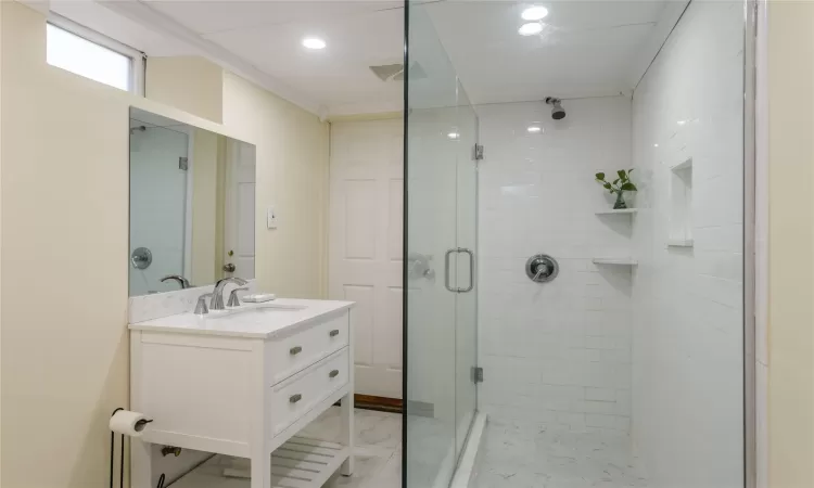 Bathroom with vanity, an enclosed shower, and molding