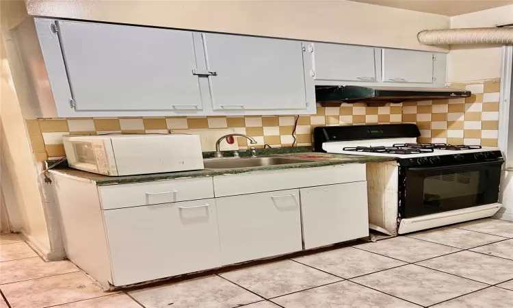 Kitchen with backsplash, sink, tiled floors