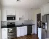 Kitchen featuring white cabinetry, sink, and stainless steel appliances