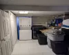 Clothes washing area featuring light tile patterned flooring and stacked washing maching and dryer