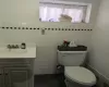 Bathroom with vanity, tile walls, and toilet