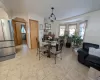 Tiled dining space with baseboard heating and a chandelier