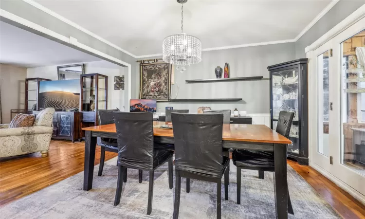 Dining area with a chandelier, hardwood / wood-style floors, and ornamental molding