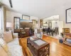 Living room with hardwood / wood-style flooring, a notable chandelier, and wood walls