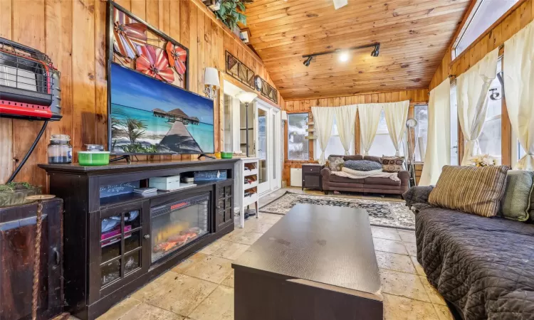 Sunroom / solarium featuring rail lighting, lofted ceiling, and wood ceiling