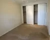 Unfurnished bedroom featuring carpet flooring, two closets, and ornamental molding