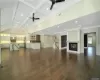 Unfurnished living room with ceiling fan, dark wood-type flooring, coffered ceiling, a multi sided fireplace, and beamed ceiling. FOR MARKETING PURPOSES ONLY.