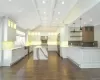 Kitchen with white cabinetry, hanging light fixtures, and light stone counters. FOR MARKETING PURPOSES ONLY.