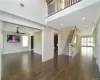 Unfurnished living room with ceiling fan, coffered ceiling, dark hardwood / wood-style flooring, beamed ceiling, and crown molding. FOR MARKETING PURPOSES ONLY.