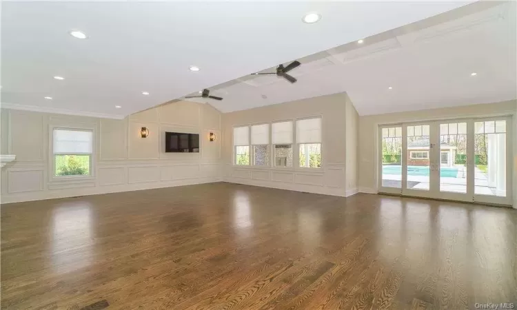 Unfurnished living room featuring ceiling fan, dark hardwood / wood-style floors, and plenty of natural light. FOR MARKETING PURPOSES ONLY.