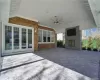 View of patio / terrace featuring ceiling fan, an outdoor stone fireplace, and french doors. FOR MARKETING PURPOSES ONLY.