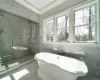 Bathroom featuring independent shower and bath, tile walls, and ornamental molding. FOR MARKETING PURPOSES ONLY.