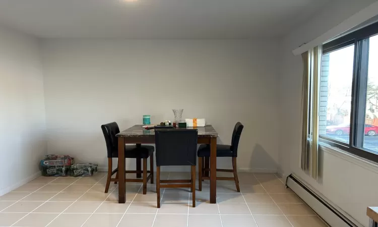 Tiled dining area with baseboard heating