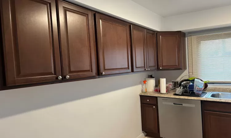 Kitchen featuring dark brown cabinets, stainless steel dishwasher, and sink