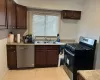 Kitchen with sink, black gas range oven, stainless steel dishwasher, dark brown cabinets, and light tile patterned floors