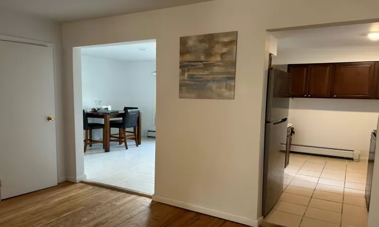 Hall with light wood-type flooring and baseboard heating