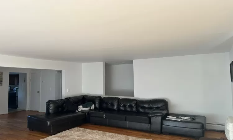 Living room featuring a baseboard heating unit and hardwood / wood-style flooring