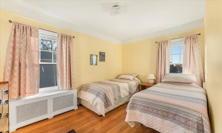 Bedroom featuring radiator and hardwood / wood-style flooring