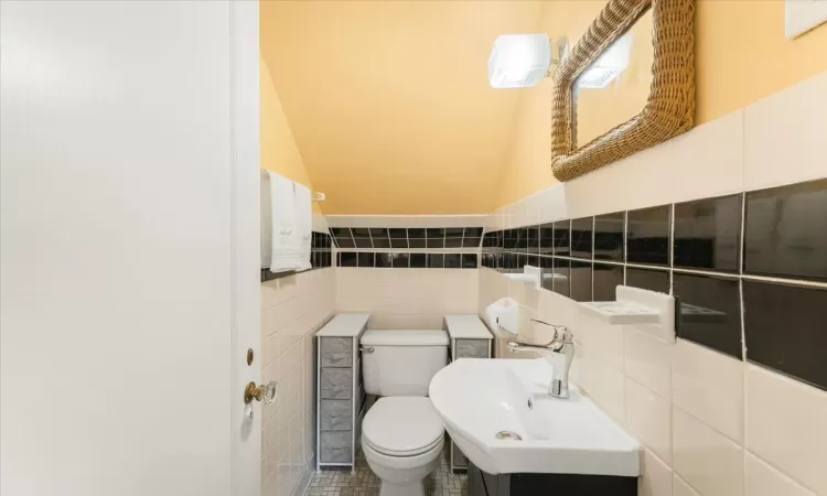 Bathroom with tile patterned floors, sink, tile walls, and toilet