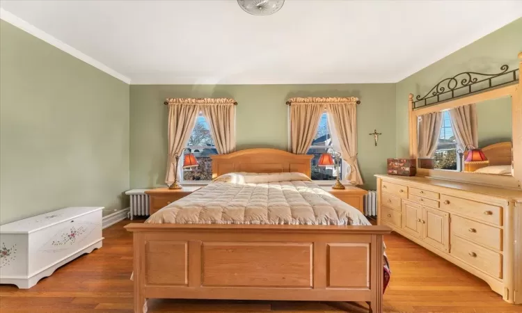 Bedroom with radiator, crown molding, and light hardwood / wood-style floors