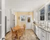 Kitchen featuring light stone countertops, ornamental molding, stainless steel appliances, sink, and white cabinets