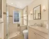 Bathroom featuring vanity, a shower with shower door, and tile walls