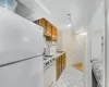 Kitchen with white appliances, backsplash, track lighting, sink, and light tile patterned floors