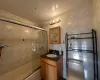 Full bathroom featuring toilet, vanity, tile walls, and combined bath / shower with glass door