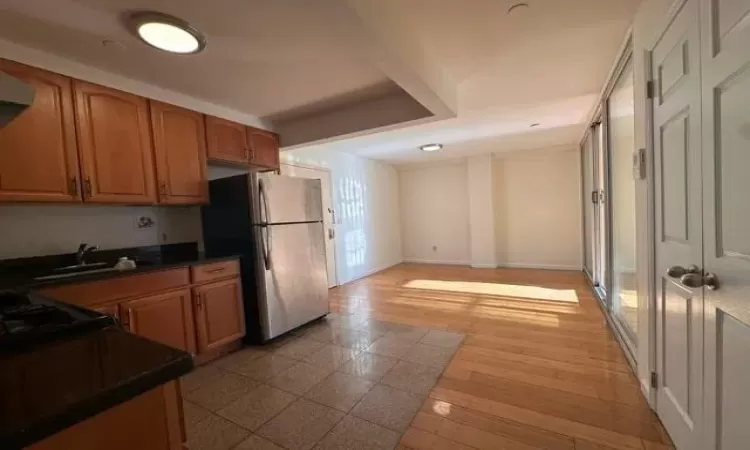 Kitchen with stainless steel refrigerator, sink, and light hardwood / wood-style floors