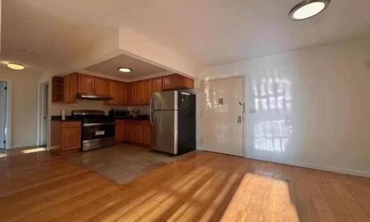 Kitchen with light wood-type flooring and appliances with stainless steel finishes