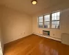 Spare room with hardwood / wood-style floors and a baseboard heating unit