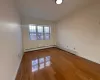 Empty room featuring hardwood / wood-style floors and a baseboard radiator