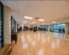 Workout area with a drop ceiling and light hardwood / wood-style floors