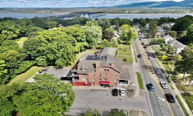 Aerial view featuring the subject property the exterior store entrance the parking lot plus a water view of the Hudson River...