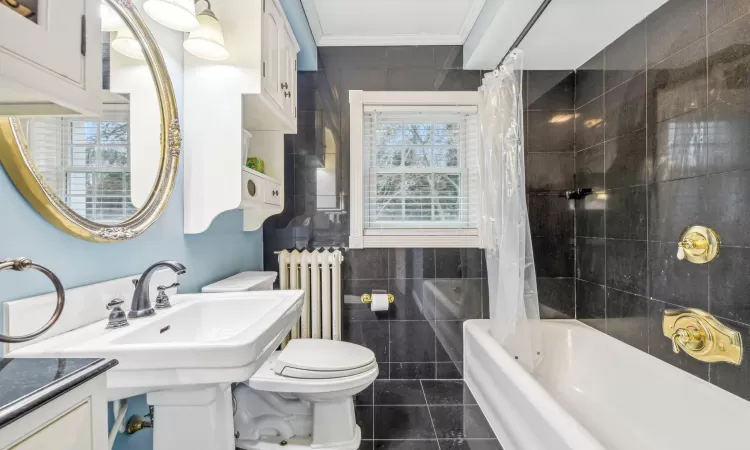 Bathroom with tile patterned floors, crown molding, sink, and tasteful backsplash